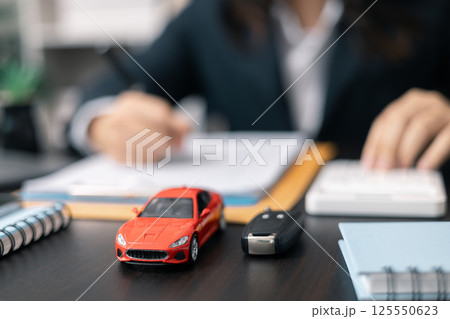 Dealership offered various finance options, including an auto loan or lease, making it easier to buy or rent a car from the company. Agent reviewed contract, finalizing insurance agreement. Dealership offered various finance options, including an auto loan or lease, making it easier to buy or rent a car from the company. Agent reviewed contract, finalizing insurance agreement. 125550623