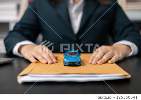 Dealership offered various finance options, including an auto loan or lease, making it easier to buy or rent a car from the company. Agent reviewed contract, finalizing insurance agreement. Dealership offered various finance options, including an auto loan or lease, making it easier to buy or rent a car from the company. Agent reviewed contract, finalizing insurance agreement. 125550641