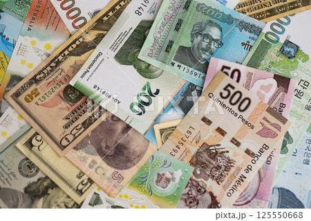 Big amount of money bills of different currencies and countries. Assortment background of international cash in big pile close up Big amount of money bills of different currencies and countries. Assortment background of international cash in big pile close up 125550668