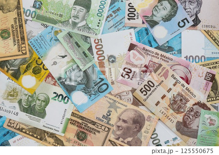 Big amount of money bills of different currencies and countries. Assortment background of international cash in big pile close up Big amount of money bills of different currencies and countries. Assortment background of international cash in big pile close up 125550675