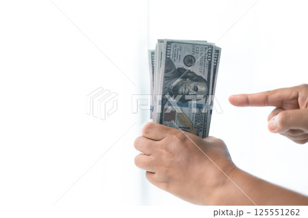 She carefully counted the dollar bills in her hand, managing her business finances and prioritizing saving for future investments. dollar, finance, money, cash, currency, bill, banknote, business. 125551262
