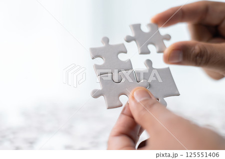Team with piece of jigsaw puzzle as critical component of business strategy, understanding teamwork and collaboration were essential for achieving success and realizing concept of well-executed plan. Team with piece of jigsaw puzzle as critical component of business strategy, understanding teamwork and collaboration were essential for achieving success and realizing concept of well-executed plan. 125551406