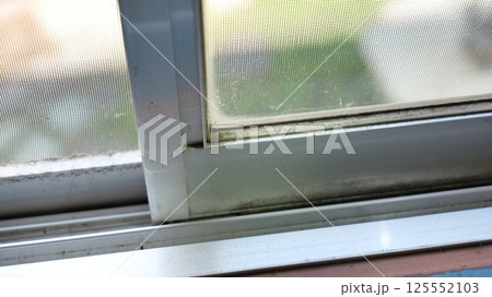 カビが付着して汚れたサッシ窓と網戸 125552103