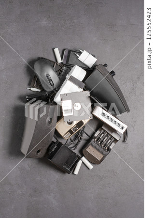 Old electronic devices on a black background. The concept of recycling used gadgets. Old electronic devices on a black background. The concept of recycling used gadgets. 125552423