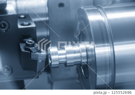 The CNC lathe machine forming cutting the cam shaft parts in the light blue scene. 125552696