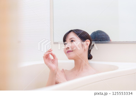 家のお風呂に入ってゆっくりとリラックスをするミドルの女性 125553334