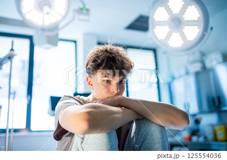 Depressed teenage patient sitting on hospital bed, waiting for doctor. Depressed teenage patient sitting on hospital bed, waiting for doctor. 125554036