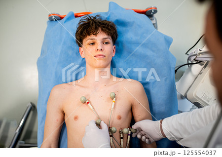 Preoperative EKG examination of teenage patient in hospital setting. Preoperative EKG examination of teenage patient in hospital setting. 125554037