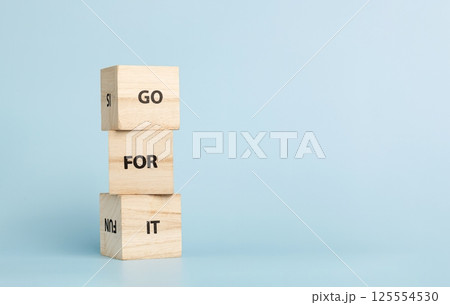 Wooden cubes with inscriptions Go For It on a blue background 125554530