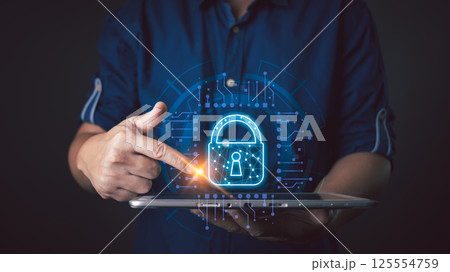 A person interacts with a glowing lock icon on a tablet, symbolizing secure cyber data protection, showcasing technology, innovation, and safeguarding sensitive information in the digital age. 125554759