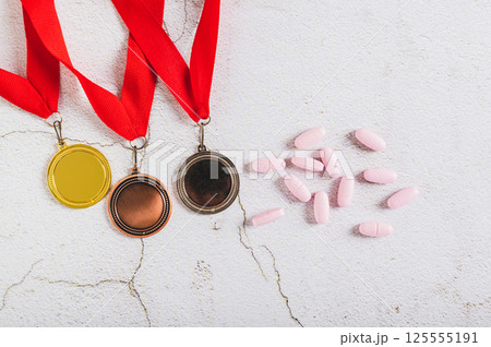 Medals and doping pills on gray background top view 125555191
