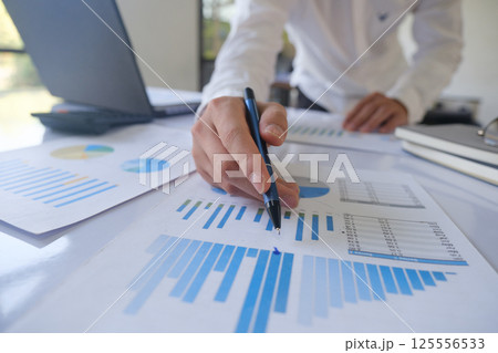 Professional businessman analyzing financial graphs investment marketing data. Professional businessman analyzing financial graphs investment marketing data. 125556533