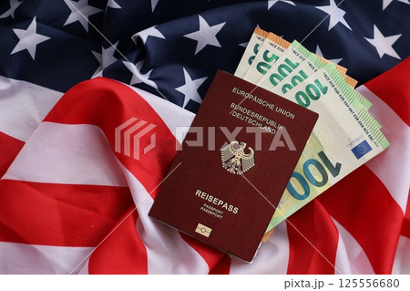 Red German passport of European Union and money on United States national flag background 125556680