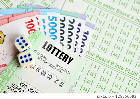 Green lottery tickets and indonesian money bills on blank with numbers for playing lottery Green lottery tickets and indonesian money bills on blank with numbers for playing lottery 125556692