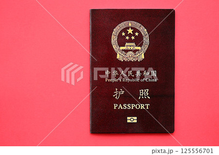 Red passport of People Republic of China. PRC chinese passport on bright background Red passport of People Republic of China. PRC chinese passport on bright background 125556701