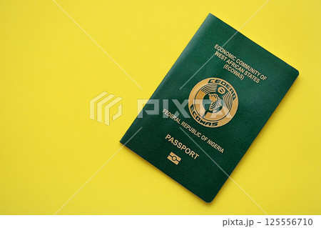 Green Nigerian passport on yellow background close up 125556710