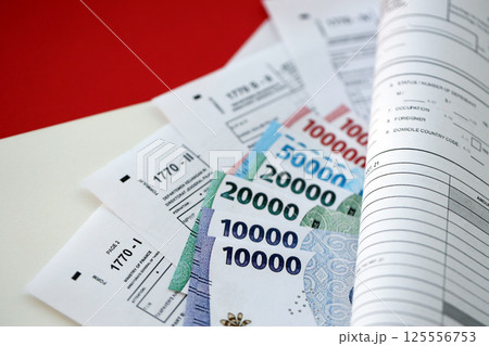Indonesian tax forms 1770 Individual Income Tax Return and others with money on table Indonesian tax forms 1770 Individual Income Tax Return and others with money on table 125556753