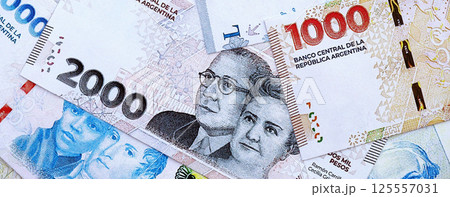 Argentine pesos money bills in big amount lies on white table close up Argentine pesos money bills in big amount lies on white table close up 125557031