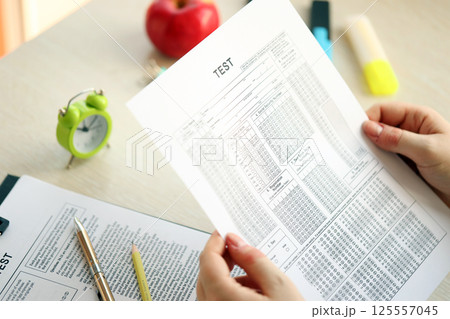 Female student hands testing in exercise and hold exam paper sheet with pencil at school test room Female student hands testing in exercise and hold exam paper sheet with pencil at school test room 125557045
