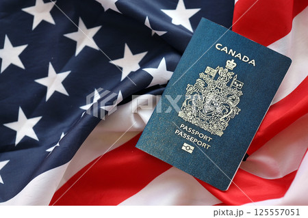 Canadian passport on United States national flag background close up. Tourism and diplomacy 125557051