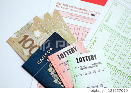 Lottery tickets lies with canadian dollars on gambling sheets with numbers for marking to play lottery 125557059