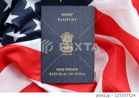 Blue Indian passport on United States national flag background close up Blue Indian passport on United States national flag background close up 125557124