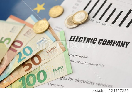 European union Euro money bills and coins with european electricity utility bill on table 125557229