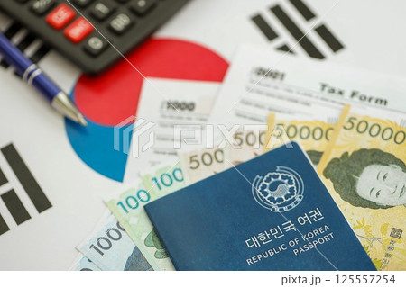 South Korean won money bills lies on table with pen, calculator, passport and tax forms South Korean won money bills lies on table with pen, calculator, passport and tax forms 125557254