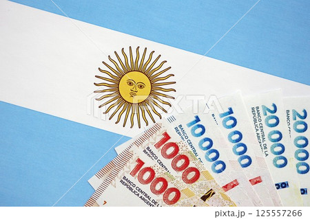 Argentine pesos money bills in big amount lies on Argentina flag close up 125557266