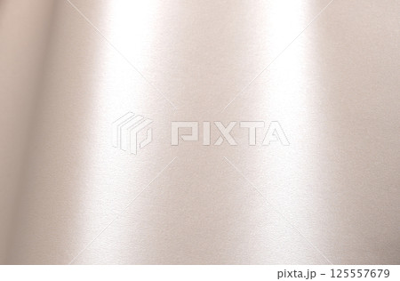 Champagne beige paper background with a pearlescent satin texture and soft, glowing sheen. Pale gold Champagne beige paper background with a pearlescent satin texture and soft, glowing sheen. Pale gold 125557679