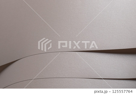 Paper background with satin pearlescent texture. Matte layered folds, smooth surface in pale gold Paper background with satin pearlescent texture. Matte layered folds, smooth surface in pale gold 125557764