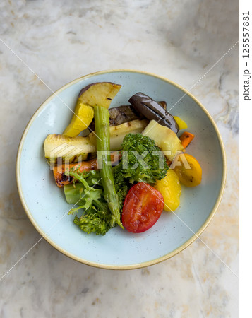 Colorful roasted vegetables including broccoli, tomato, zucchini, asparagus and carrots served in a light blue ceramic bowl perfect for healthy eating, vegan meals, food photography and culinary menus Colorful roasted vegetables including broccoli, tomato, zucchini, asparagus and carrots served in a light blue ceramic bowl perfect for healthy eating, vegan meals, food photography and culinary menus 125557881