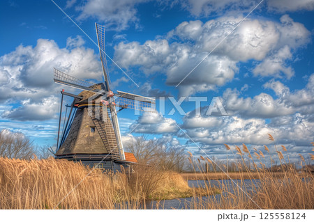 Landscape of windmill park under fluffy clouds in a clear blue sky Landscape of windmill park under fluffy clouds in a clear blue sky 125558124
