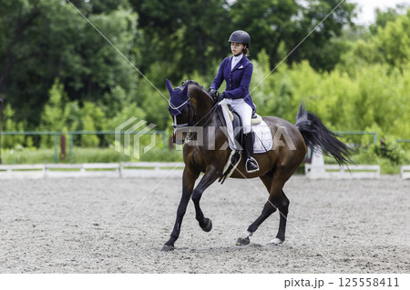 Young Equestrian Performing Dressage Test at Horse Riding Competition 125558411