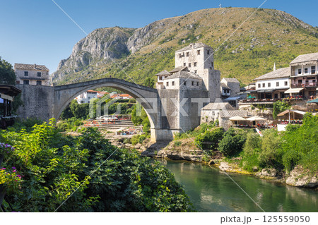 The Stari Most bridge, old bridge on Neretva river in Mostar town, Bosnia and Herzegovina, Europe. Picturesque stone bridge crossing a river with historic buildings in the background. 125559050