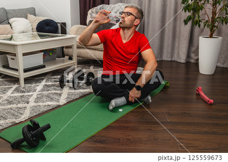 Hydrating after a workout at home gym 125559673
