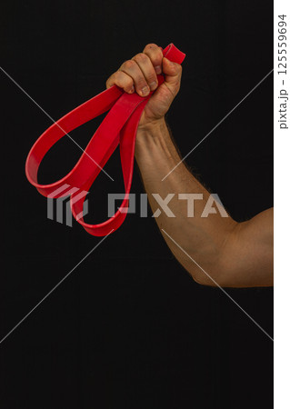 Strong grip on red resistance bands during workout Strong grip on red resistance bands during workout 125559694