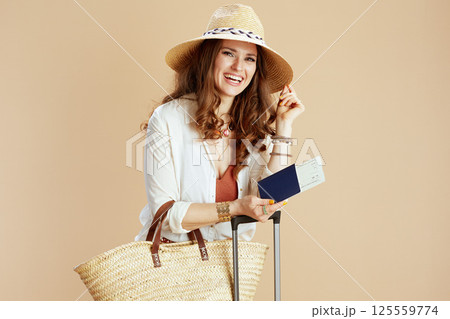 happy elegant woman in blouse and shorts against beige 125559774