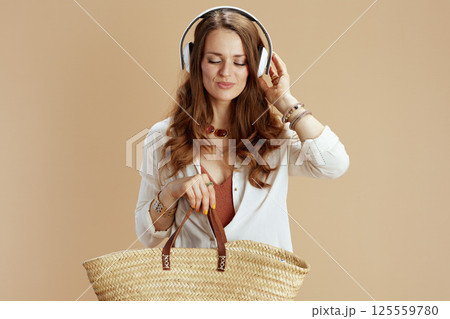 relaxed elegant woman in blouse and shorts on beige 125559780