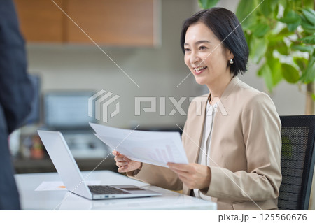 オフィスで打ち合わせをするミドル女性 オフィスで打ち合わせをするミドル女性 125560676