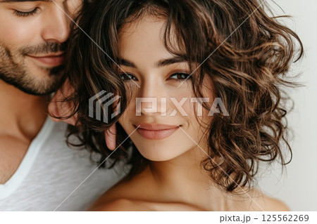 Couple sharing a tender moment while brushing hair in soft indoor lighting 125562269