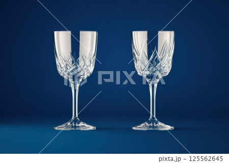Elegant Czech crystal glasses with intricate engravings on a deep blue background 125562645