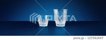 Elegant Czech crystal glass with intricate engravings against a deep blue background Elegant Czech crystal glass with intricate engravings against a deep blue background 125562647