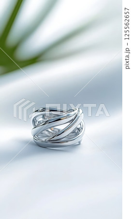 Stylish silver earrings with intertwining lines featuring matte and polished finishes 125562657