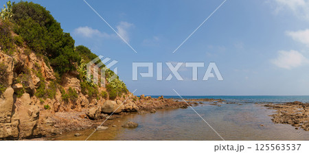 Panoramic View of Rocky Coastal Shoreline with Cliffs and Sea 125563537