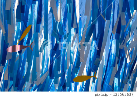 Colorful fish decorations amid blue and white streamers Colorful fish decorations amid blue and white streamers 125563637