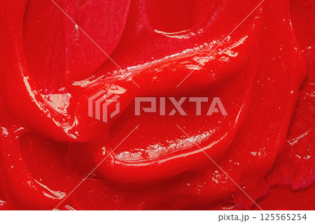 Red gel texture. Cosmetic clear liquid cream smudge. Skin care product sample closeup. Toothpaste or wax 125565254