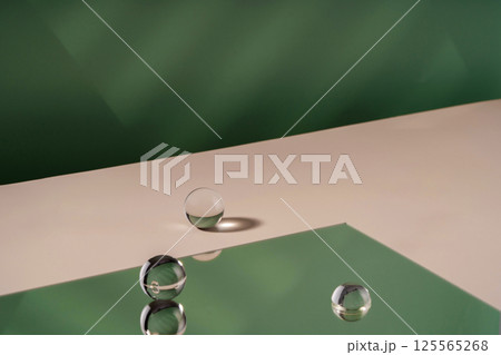 Cosmetic background podium for product presentation. Showcase mock up for perfume advertising, cosmetics stand, branding scene with ball. Green backdrop with transparent sphere decor, display 125565268