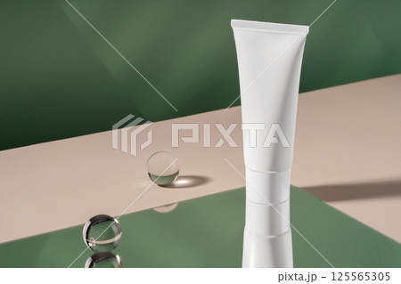Cosmetic cream mockup showcase product presentation. Showcase mock up for advertising, cosmetics stand, branding scene with ball and mirror, shadow and light. Green backdrop with stylish props 125565305