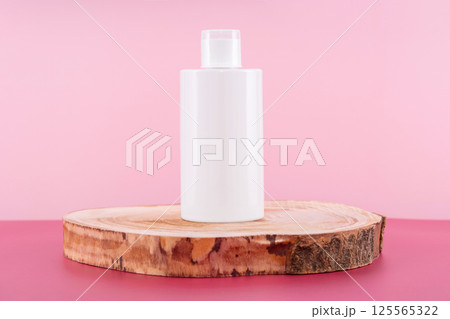 Cleaning agent, softener or liquid soap bottle on round wooden podium. Presentation of detergent mockup on pink background. Home sanitary liquid for laundry in plastic container Cleaning agent, softener or liquid soap bottle on round wooden podium. Presentation of detergent mockup on pink background. Home sanitary liquid for laundry in plastic container 125565322